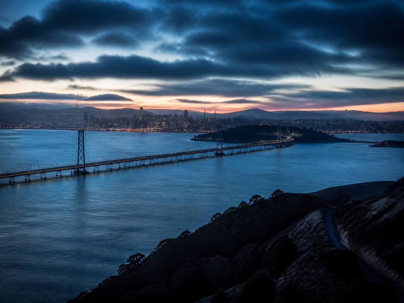 San Francisco Bay Area at blue hour with the bay, the bridge span and the city skyline in the distance